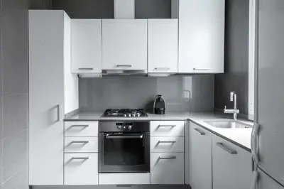 a kitchen with white cabinets and a stove and a sink at Barcelona Apartment Val in Barcelona