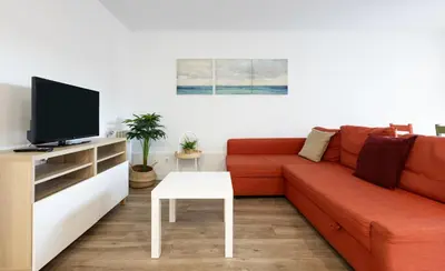 a living room with a red couch and a tv at Stay U-nique Apartments Fabra i Puig in Barcelona