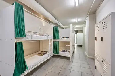 a room with white cabinets and green curtains at Hola Hostal Eixample in Barcelona