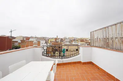 a balcony with a table and a view of a city at Ola Living Camp Nou in Hospitalet de Llobregat