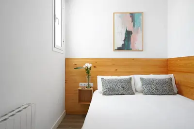 a bedroom with a white bed with two pillows at Ola Living Camp Nou in Hospitalet de Llobregat