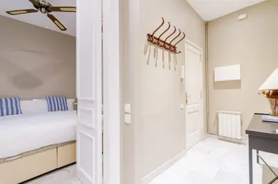 a white bedroom with a bed and a desk at BCN Apartments 41 in Barcelona