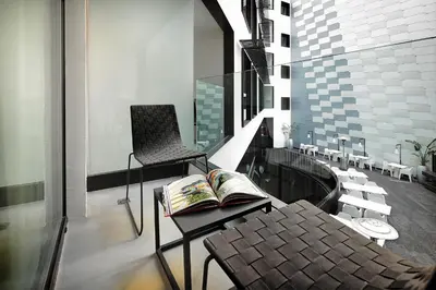 a balcony with a chair and a book on a table at Olivia Balmes Hotel in Barcelona