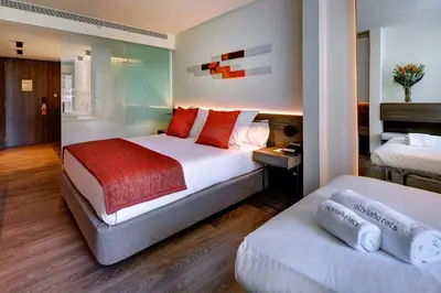a hotel room with two beds and a bathroom at Olivia Balmes Hotel in Barcelona