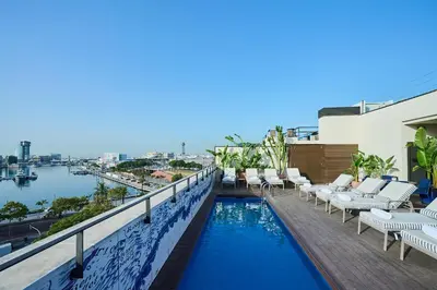 a swimming pool on the roof of a building with lounge chairs at H10 Port Vell 4* Sup in Barcelona