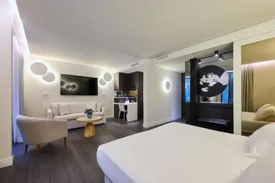 a bedroom with a bed and a living room at H10 Port Vell 4* Sup in Barcelona