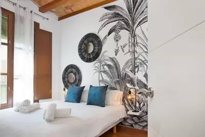a bedroom with a white bed with blue pillows at Stay U-nique Apartments Girona in Barcelona