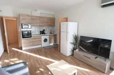 a living room with a refrigerator and a kitchen at Vallparadis apartment in Terrassa