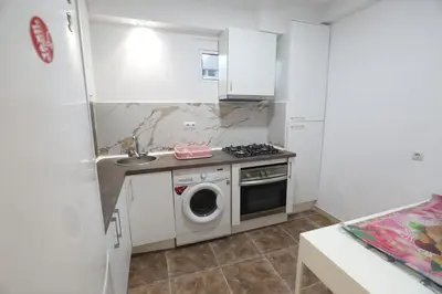 a small kitchen with a washing machine and a sink at Vallparadis apartment in Terrassa