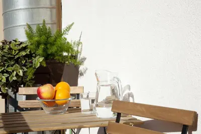 a wooden table with a bowl of fruit and a blender at My Address in Barcelona Old Town in Barcelona