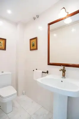 a bathroom with a sink and a toilet and a mirror at Comfortable House in Sitges with Shared Pool in Sitges