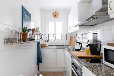 a kitchen with white cabinets and a counter top at Con patio y a 5 minutos de la playa in Sitges