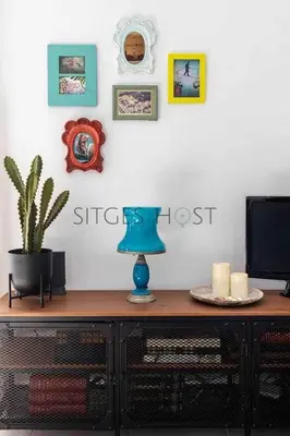 a table with a tv and a blue lamp on it at Con patio y a 5 minutos de la playa in Sitges