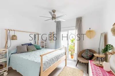 a bedroom with a bed and a ceiling fan at Con patio y a 5 minutos de la playa in Sitges
