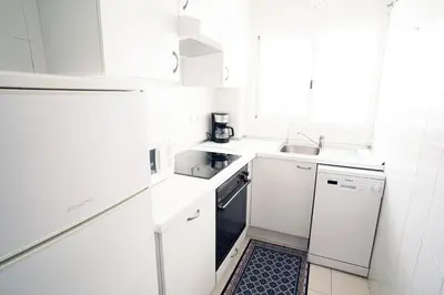 a white kitchen with a sink and a dishwasher at ESPIGALL in Vilanova i la Geltrú