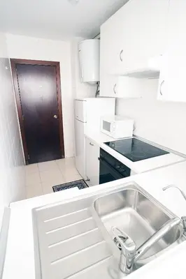 a white kitchen with a sink and a stove at ESPIGALL in Vilanova i la Geltrú