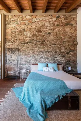 a bed in a room with a brick wall at RUSTIC & CHIC b&b in Granollers