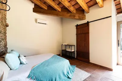 a bedroom with a bed in a room with wooden ceilings at RUSTIC & CHIC b&b in Granollers