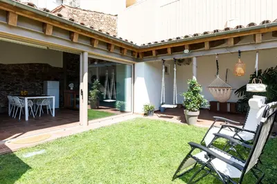 a patio with a lawn and a chair on it at RUSTIC & CHIC b&b in Granollers