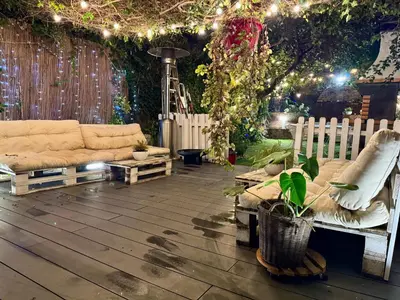 a table and chairs in a garden with lights at casa en Masnou junto a playa y tren in Masnou