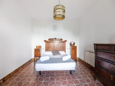 a bedroom with a bed and a dresser at Mansion in St Martí with Vineyards & Garden in San Martín Sarroca