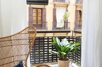 a balcony with a chair and a potted plant at En Casa de Calders 5 in Barcelona