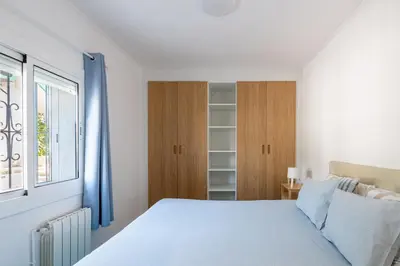a white bedroom with a bed and a window at Sitges Blue - completamente reformado en 2025 in Sitges