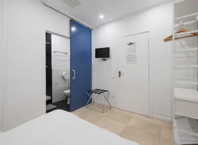 a bedroom with a blue door and a bed and a toilet at No Limit Barcelona Central in Barcelona