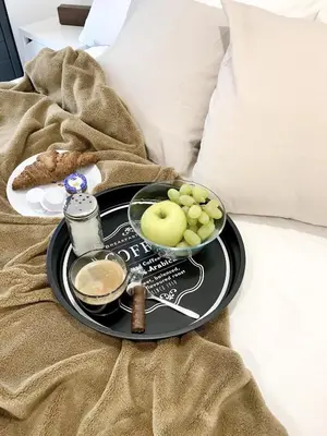 a tray with a plate of food on a bed at Mon Residence Sant Jeroni in Manresa