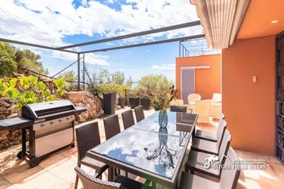 a kitchen with white cabinets and stainless steel appliances at VILLA DUMAS with amazing sea views, AC and private pool in Sitges