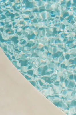 a close up of a pool of water with a beach at Playa Grande by Tropical in Gavà