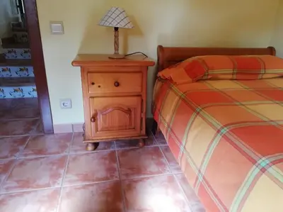 a bedroom with a bed and a table with a lamp at MAS DEL VENT- Barbacoa, jardín, piscina privada y vistas a mar in Cunit
