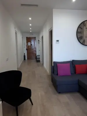 a living room with a couch and a clock on the wall at Beautiful Apartment on Las Ramblas with Port views in Barcelona