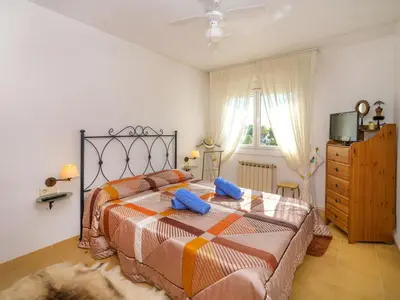 a bedroom with a bed with two blue pillows on it at Holiday Home Envalira by Interhome in Cunit