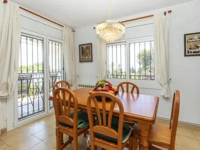 a dining room with a table and chairs and windows at Holiday Home Envalira by Interhome in Cunit