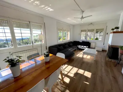 a living room with a table and a couch at CASA PARAÍSO PISCINA TRANQUILIDAD in Sant Cebrià de Vallalta