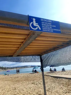a sign on a beach with people sitting under umbrellas at APARTAMENTO EN SEGUNDA LINEA DE MAR, WIFI & A.C in Cubelles