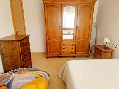 a bedroom with a dresser and a cabinet and a bed at APARTAMENTO EN SEGUNDA LINEA DE MAR, WIFI & A.C in Cubelles