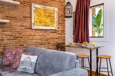 a living room with a couch and a brick wall at Stay U-nique Apartments Ramón y Cajal in Barcelona