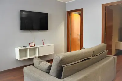 a living room with a couch and a tv at Alguera Hola Apartments in Barcelona