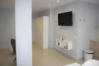 a living room with a tv on a white wall at Alguera Hola Apartments in Barcelona