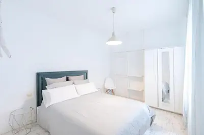 a white bedroom with a large white bed with white pillows at Nordic apartment Sagrada Familia in Barcelona
