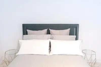 a bed with white pillows in a white bedroom at Nordic apartment Sagrada Familia in Barcelona