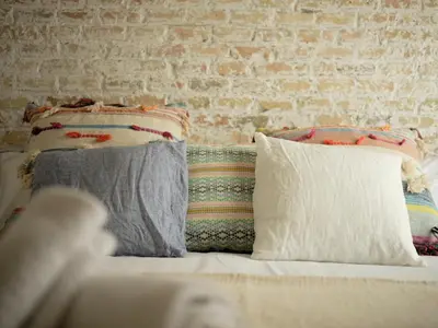 two pillows on a bed with a brick wall at Poble Nou I You Stylish Apartments in Barcelona