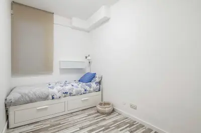 a small bedroom with a bed and a mirror at Nordic Apartment II Sagrada Familia in Barcelona