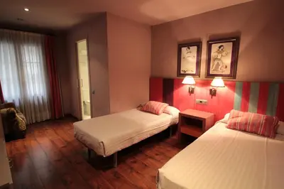 a hotel room with two beds with red walls at Hotel Annex - Rey Don Jaime I in Barcelona