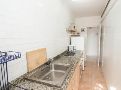 a kitchen with a sink and a refrigerator at Sol & Relax en centro, Sitges. in Sitges