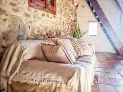 a couch in a room with a stone wall at Masia Mediterranian Country House Ca l'Isidre Torrent in Sant Cebrià de Vallalta
