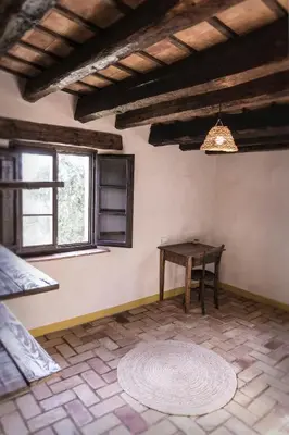 a room with a table and a chair and a window at Masia Mediterranian Country House Ca l'Isidre Torrent in Sant Cebrià de Vallalta