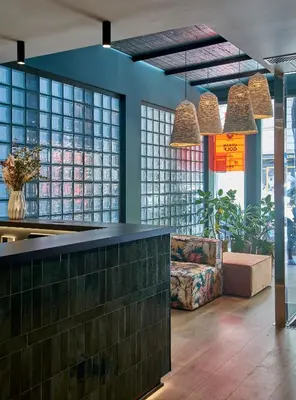 a lobby with a bar and a couch and windows at The Moods Oasis in Barcelona